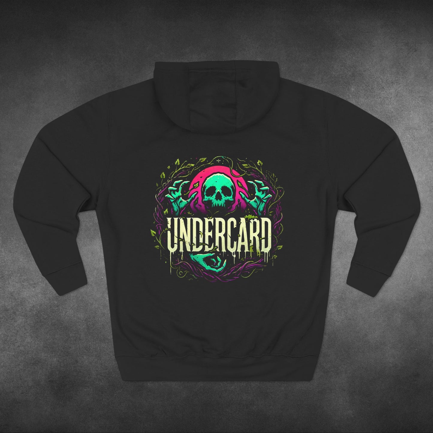 A black hoodie featuring a vibrant neon green and pink skull graphic in the center of the back, surrounded by twisted vines. Below the skull, the word "Undercard" is prominently displayed in stylized, dripping white letters. The design has a bold, edgy aesthetic, with the hoodie shown against a textured grey background.